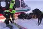 Redningsarbejdere foran en helikopter i Aosta-dalen i de italienske alper, hvor flere mennesker er omkommet i snemasserne.