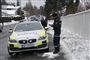 Politiet er torsdag til stede foran Norges justitsministers bolig. Hans samlever er sigtet for at stå bag afbrændingen af parrets bil natten til søndag.