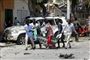 Civile bærer afsted med liget af en mand, efter en meget kraftig bilbombe er eksploderet i Mogadishu.
