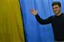 Den ukrainske komiker og præsidentkandidat Volodimir Zelenskij vinker til fotograferne, da han søndag stemte ved præsidentvalget.