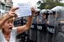 En kvinde deltager i en demonstration uden for den venezuelanske flådes hovedkvarter i hovedstaden Caracas lørdag. På hendes skilt står: "Ven: du som forsvarer en korrupt regering, følg forfatningen".