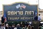 Israels premierminister, Benjamin Netanyahu (th) iklædt jakkesæt, og USA's Israel-ambassadør, David Friedman (tv), klapper, da et stort skilt afsløres på Golan-højderne med navnet på en ny, lille bosættelse.