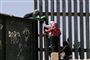 Migranter klatrer over et grænsehegn fra Mexico til USA lørdag. Trump har truet Mexico med forhøjet told på alle mexicanske varer, hvis indvandringen ikke bliver mindsket markant.
