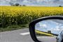 Der ventes trængsel på vejene i skoleferiens første weekend, både på tværs af landet og sydpå mod Tyskland. Generelt vil vejnettet i sommer være mest belastet af biltrafik på lørdage i tidsrummet kl. 11-15, forudser Vejdirektoratet. Her udsigt fra chaufførsædet til rapsmarker i fuldt flor på Sjælland, maj 2019.