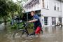 Stormen Barry har oversvømmet gaderne i flere byer i delstaten Louisiana i USA. Her ses en mand, der lørdag trækker sin cykel gennem vandmasserne i byen Mandeville.