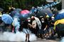 En demonstrant kaster en tåregasgranat tilbage mod politiet under lørdagens sammenstød i Hongkong. Ud over tåregas anvender politiet også gummikugler for at sprede demonstranterne.