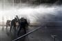 Demonstranter dukker sig for vandkanoner under fredagens protester i Santiago, Chiles hovedstad.