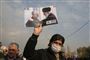 En mand holder et billede af den dræbte general, Qassem Soleimani, sammen med Irans øverste leder, ayatollah Ali Khamenei, under en demonstration i Teheran fredag.