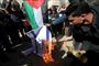 Palæstinensiske demonstranter brænder det israelske flag af under en demonstration i den sydlige del af Gazastriben fredag.