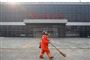 Kinas hovedstad, Beijing, er tydeligt påvirket af virusudbruddet i landet. Her ses en ansat iført ansigtsmaske gå forbi den normalt travle busterminal Sihui Long Distance Bus Station i Beijing.