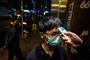 En ansat på en restaurant i Hongkong får taget sin temperatur, inden han møder på arbejde. På restauranten blev ti medlemmer af samme familie for nylig smittet med coronavirus.
