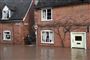 En mand forsøger at passere Church Street i Tenbury, efter at floden Teme er løbet over i det vestlige England. En person har desuden mistet livet i England som følge af stormen Dennis søndag.