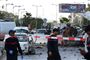 I forgrunden er kriminalteknikere på arbejde, efter to personer på en motorcykel har detoneret en sprængladning ved USA's ambassade i Tunis.