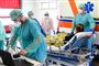 Læger og andre sundhedsansatte tilser en patient på en ny afdeling for coronasmittede, der er oprettet på Brescia Poliambulanza-hospitalet i Lombardiet. Antallet af alvorligt syge patienter på intensivafdeling er steget med 11 procent på et døgn.