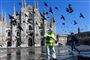 Iført beskyttelsesdragt sprøjter en medarbejder desinficerende væske på Piazza Duomo i storbyen Milano i det nordlige Italien tirsdag. Landet vil i endnu mindst to uger frem være lukket ned på grund af coronavirusset.