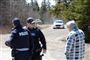 Poliktifolk fra Canadas beredne politi taler med en mand efter en omfattende jagt på en bevæbnet mand, som i weekenden skød og dræbte mindst ti mennesker i provinsen Nova Scotia.