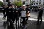 Fransk politi anholder en mand, der deltog i en 1. maj-demonstration i Paris. På hans skilt står "Lad os ikke ofre livet af frygt for døden". Den franske regering vil lempe på corona-restriktionerne fra 11. maj - men indtil videre er demonstrationer og forsamlinger ikke tilladt.