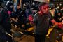 En maskeret anti-regeringsdemonstrant angriber en mand, som folk omkring mistænker for at være en pro-Beijing-demonstrant fra det kinesiske fastland. Ifølge lokale medier overlevede den blodtilsølede mand, men fik alvorlige hovedskader.