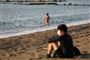 Enkeltvis nyder folk det gode vejr på stranden i bydelen Barceloneta fredag. I Barcelona må man godt gå tur og dyrke sport udendørs, men cafébesøg og familiekomsammen må vente lidt endnu.