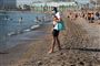 En mand med maske nyder solen på Barceloneta-stranden i Barcelona torsdag. Endnu har Spanien ikke åbnet for turister.