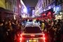 En bil forsøger at møve sig igennem en fyldt gade i Soho-området i London lørdag aften, hvor pubberne genåbnede efter lang nedlukning.
