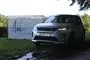 En Land Rover foran et skilt