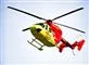 En rød og gul lægehelikopter i luften