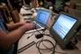 Hacker sidder foran to computere