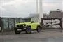 En grøn Suzuki foran grafittimur