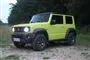 En Jimny med tændte lygter.