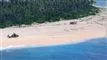 Helikopter på strand med SOS skrevet i sandet