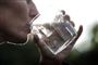 person drikker vand af et glas