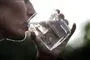 person drikker vand af et glas