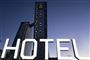 Et hotel i aftenhimmelen med et stort hvidt HOTEL-skilt i forgrunden