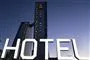 Et hotel i aftenhimmelen med et stort hvidt HOTEL-skilt i forgrunden