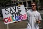 Tilhænger af konspirationsteorien QAnon med et skilt med påskriften "Save the Children"