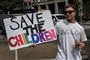 Tilhænger af konspirationsteorien QAnon med et skilt med påskriften "Save the Children"