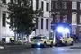 En ambulance og en lægeambulance holder parkeret med blå blink foran en ejendom
