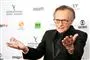 En ældre og svageligt udseende Larry King slår ud med sine arme