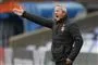 En træner står og råber ud på banen fra sidelinjen