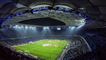 Et stort fodboldstaium om aftenen med tændte projektører 