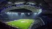 Et stort fodboldstaium om aftenen med tændte projektører 