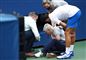 Tennisspilleren Novak Djokovic står ved en linjedommer som han har ramt på halsen