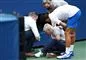 Tennisspilleren Novak Djokovic står ved en linjedommer som han har ramt på halsen