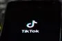 Billede af det sociale medie TikToks logo på en sort skærm med hvid skrift. Logoet ligner en node. 