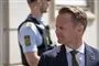 Udenrigsminister Jeep Kofod ses fra siden med en politibetjent i baggrunden.
