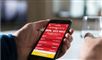Person holder en mobiltelefon med lotto-app