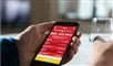 Person holder en mobiltelefon med lotto-app