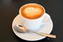 kaffekop med kaffe på underkop med teske
