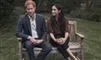 Harry og Meghan sidder på en bænk i en park